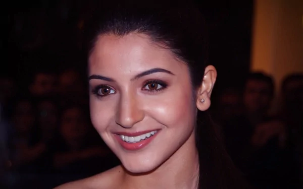 Anushka Sharma smiling at an event, captured in high-definition. This striking image serves as a vibrant desktop wallpaper and background.