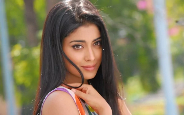 HD PC desktop wallpaper featuring a close-up portrait of celebrity Shriya Saran with a soft outdoor background.