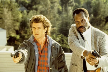 HD PC desktop wallpaper from the movie Lethal Weapon: two detectives stand side by side, aiming pistols against a sunlit outdoor backdrop.