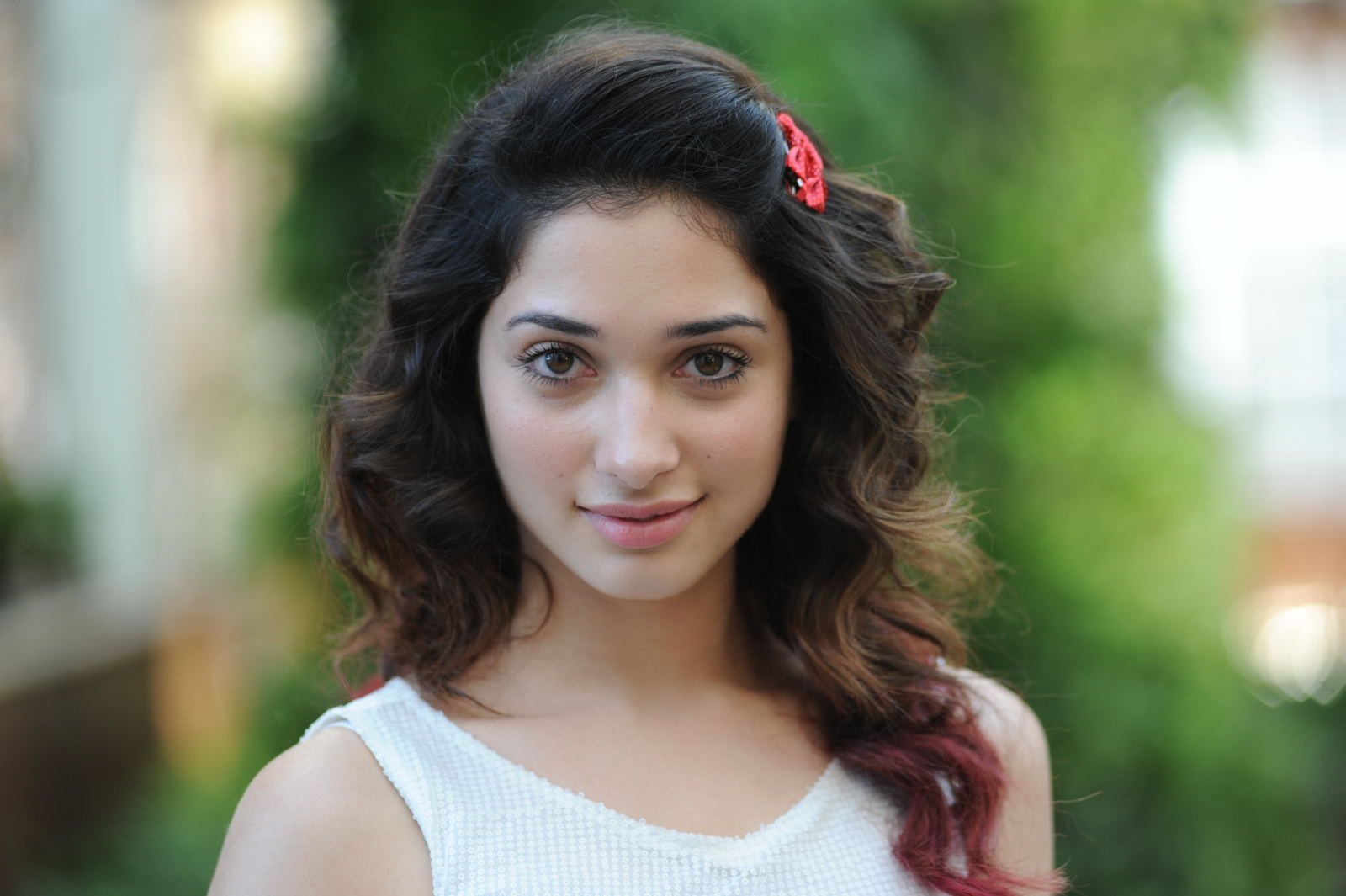 HD PC desktop wallpaper featuring celebrity Tamannaah Bhatia with soft curls, a white top, and a natural outdoor background.