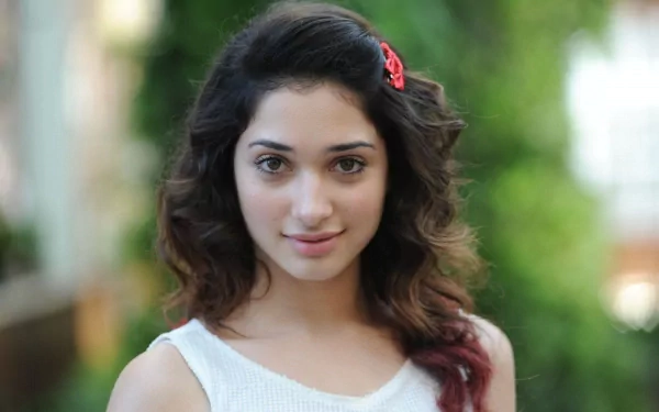 HD PC desktop wallpaper featuring celebrity Tamannaah Bhatia with soft curls, a white top, and a natural outdoor background.