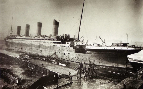 HD desktop wallpaper of the RMS Titanic, a historic passenger vehicle, docked and undergoing preparations at the shipyard.