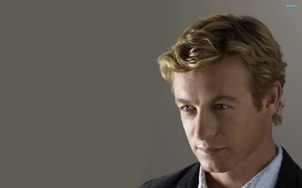 Close-up portrait of a blond man in a suit against a gray backdrop - 2K Quad HD PC desktop wallpaper tagged TV show The Mentalist.