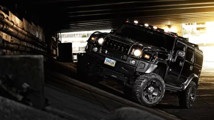 A powerful black Hummer navigating a slope under an overpass, showcasing its rugged design. This high-definition image serves as a striking desktop wallpaper.