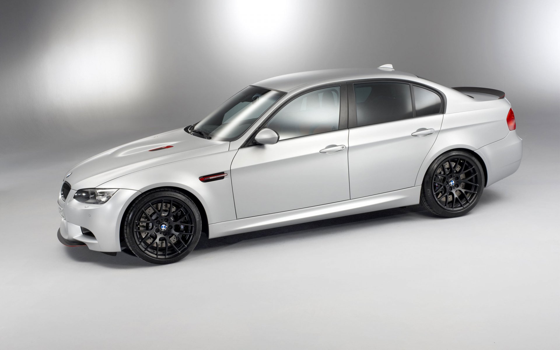 Silver BMW M3 CTR compact sedan shown in studio lighting, 2K Quad HD PC desktop wallpaper/background.