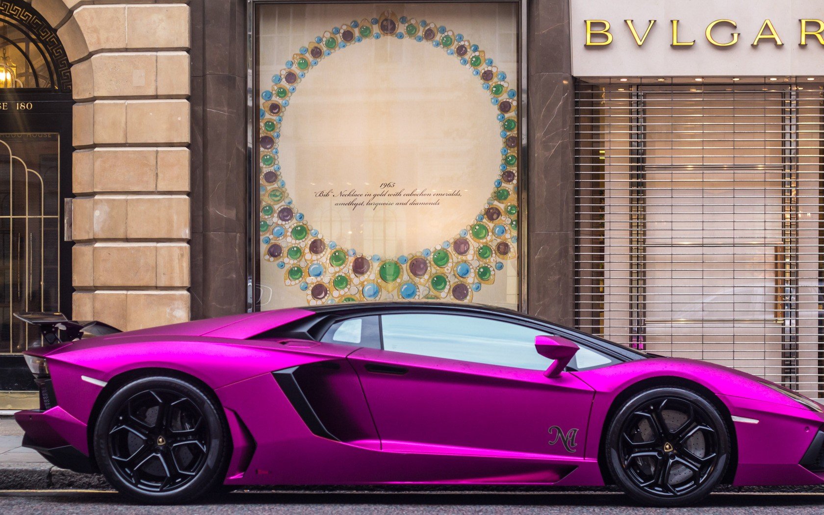 A vibrant purple Lamborghini Aventador LP 700-4 parked in front of a luxury store, captured in a high-definition PC desktop wallpaper and background.