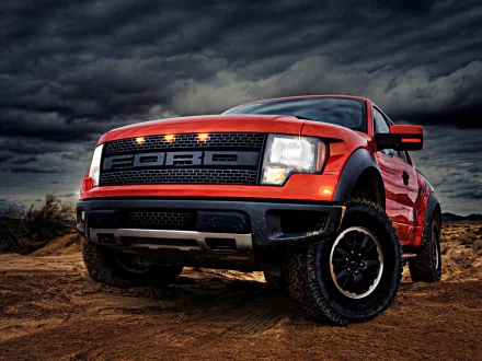 HD desktop wallpaper featuring a bold red Ford Raptor truck on rugged terrain under a dramatic cloudy sky.