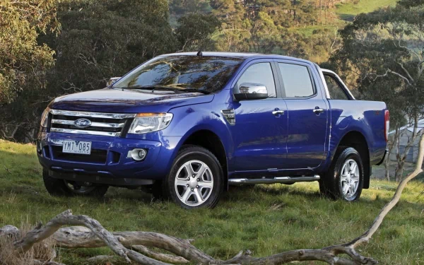 A vibrant blue Ford Ranger parked on a grassy landscape, showcasing its rugged design and versatility. An appealing HD background for your desktop or wallpaper.