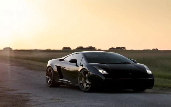 Black Lamborghini Gallardo parked on a rural road at sunset, captured in stunning 4K Ultra HD for PC desktop wallpaper and background.