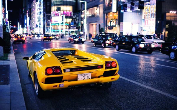 Yellow Lamborghini Diablo vehicle on a neon-lit city street at night — HD PC desktop wallpaper/background.