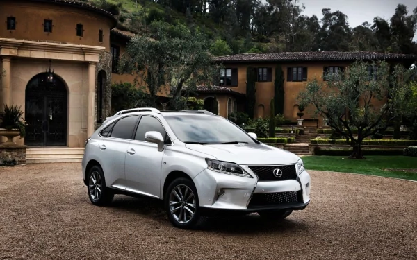 HD PC desktop wallpaper of a silver Lexus vehicle (SUV) parked on a gravel driveway before a Mediterranean-style villa, framed by trees and manicured gardens.