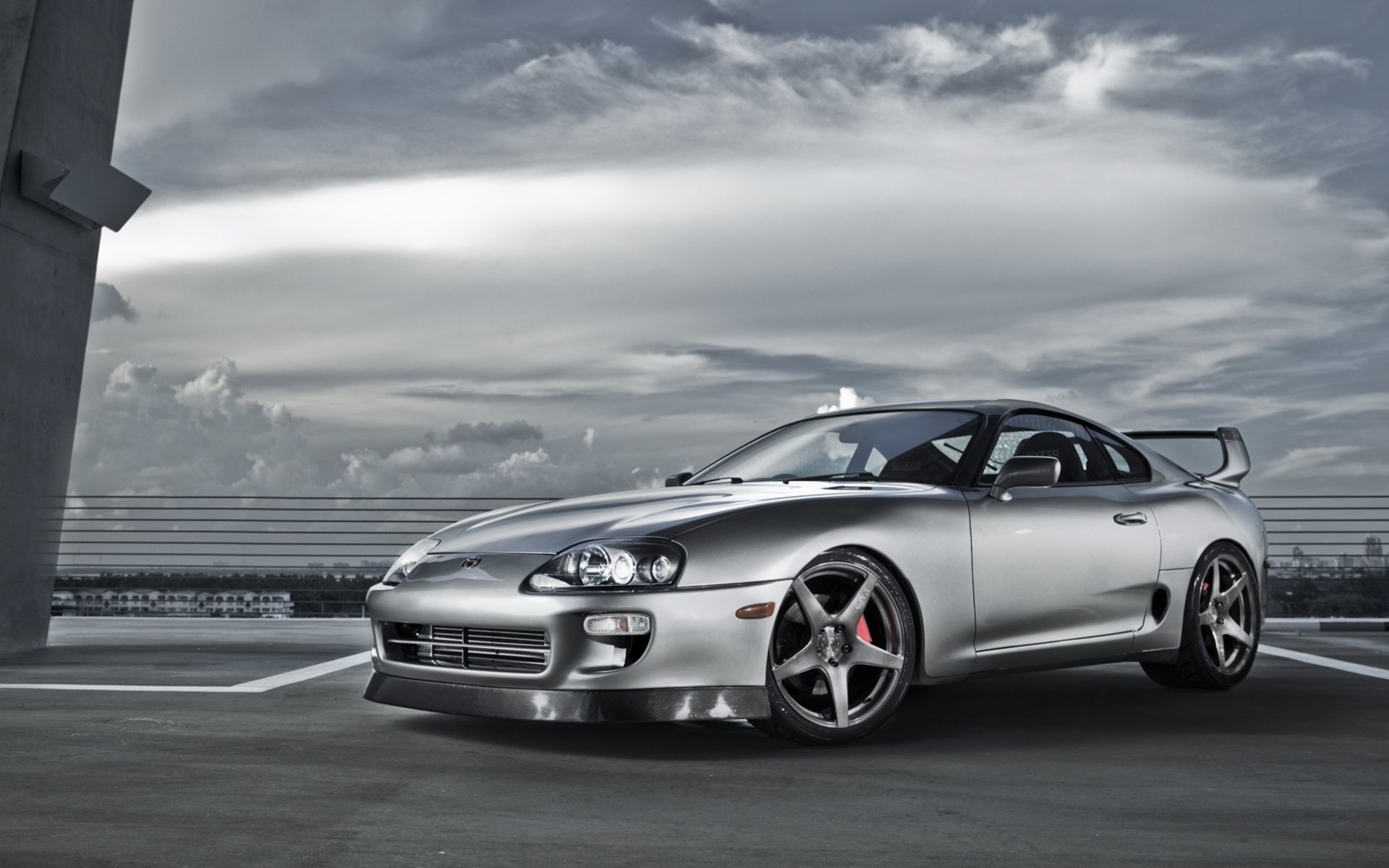 HD desktop wallpaper featuring a sleek silver Toyota sports car parked under a cloudy sky, showcasing its aerodynamic design and sporty wheels.