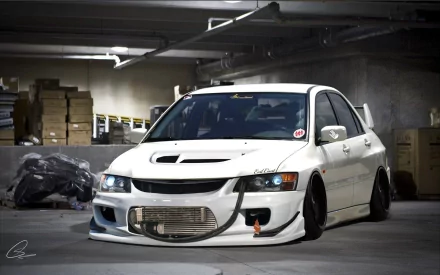 White Mitsubishi performance vehicle (Evo) parked in a dim concrete garage with exposed intercooler and aggressive bodywork — 2K Quad HD PC desktop wallpaper background.