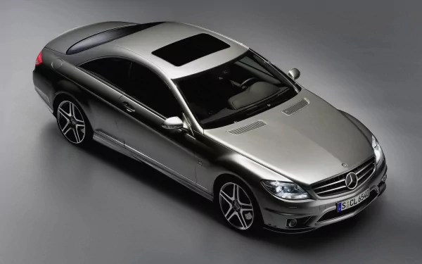 Sleek silver Mercedes coupe vehicle seen from a high angle on a gray background — HD PC desktop wallpaper and background highlighting its contours and sunroof.