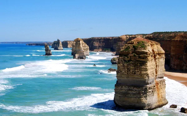 Majestic cliffs rise from the turquoise ocean at The Twelve Apostles, capturing the beauty of nature in a stunning HD desktop wallpaper.