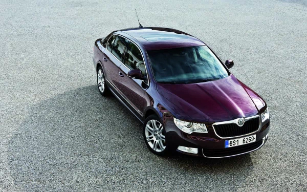 HD PC desktop wallpaper featuring a sleek, dark purple Skoda vehicle parked on a textured pavement, captured from an elevated angle.