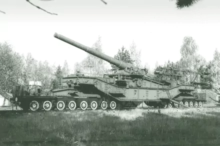 HD desktop wallpaper depicting a large military artillery vehicle in a forested landscape with trees in the background.
