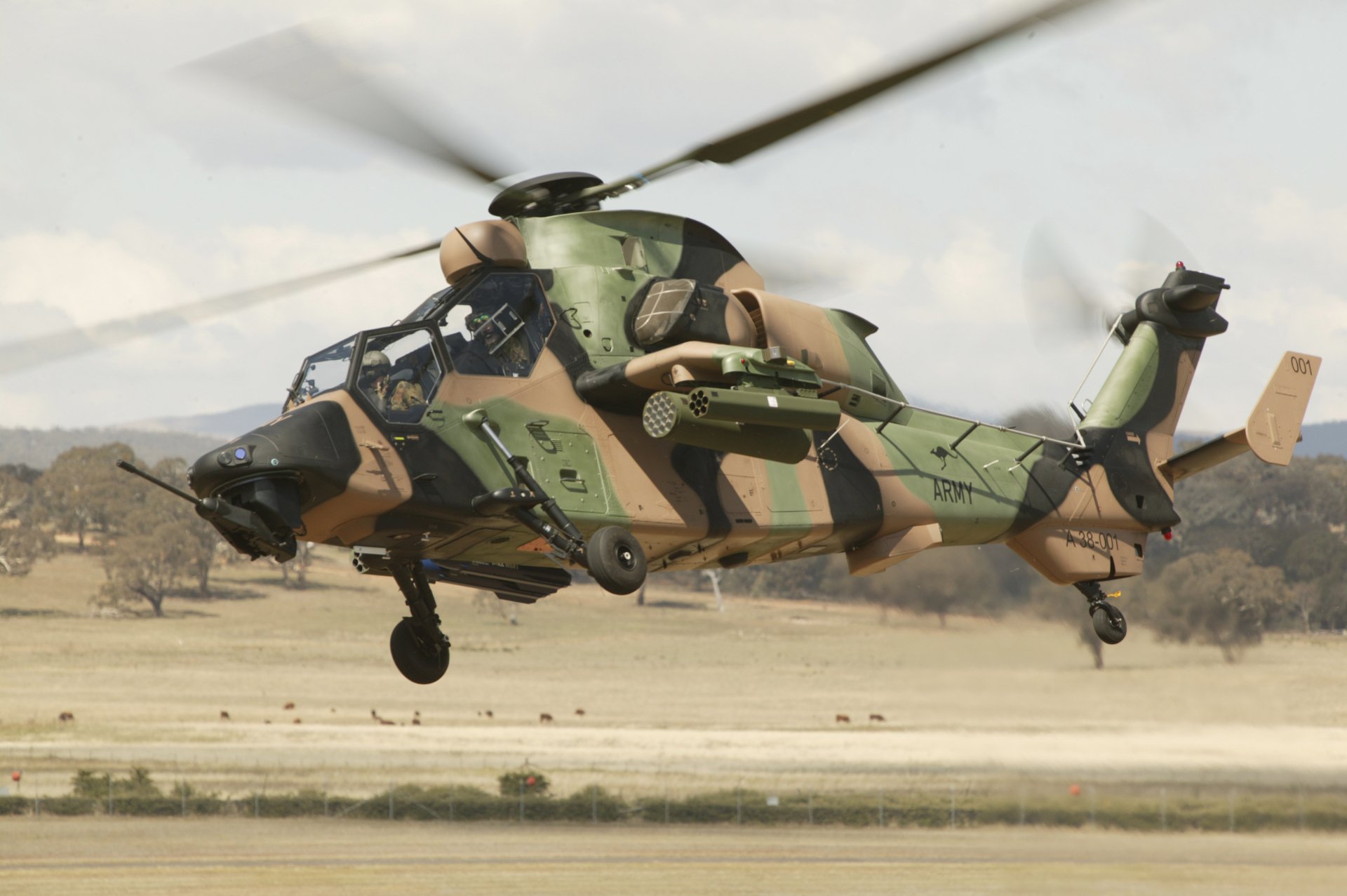 Eurocopter Tiger attack helicopter in military camouflage flying low over a runway — 2K Quad HD PC desktop wallpaper/background.