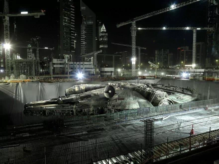 An HD desktop wallpaper featuring the Millennium Falcon amidst a construction site at night, blending sci-fi elements with urban surroundings from the Star Wars universe.