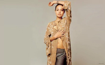 HD PC desktop wallpaper featuring celebrity Angelina Jolie posing gracefully in a sheer, embroidered beige jacket against a neutral background.