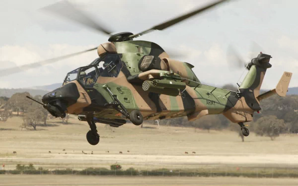 Eurocopter Tiger attack helicopter in military camouflage flying low over a runway — 2K Quad HD PC desktop wallpaper/background.