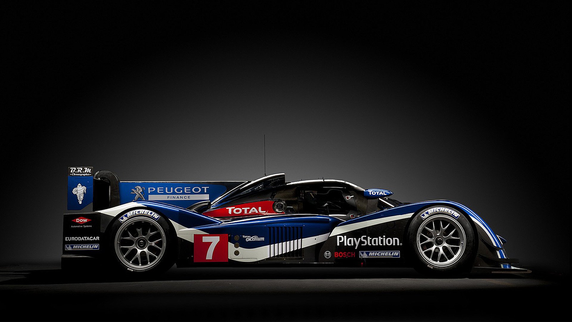 HD PC desktop wallpaper featuring a sleek Peugeot race car in black, blue, and white with prominent sponsor logos and the number 7 on the side.