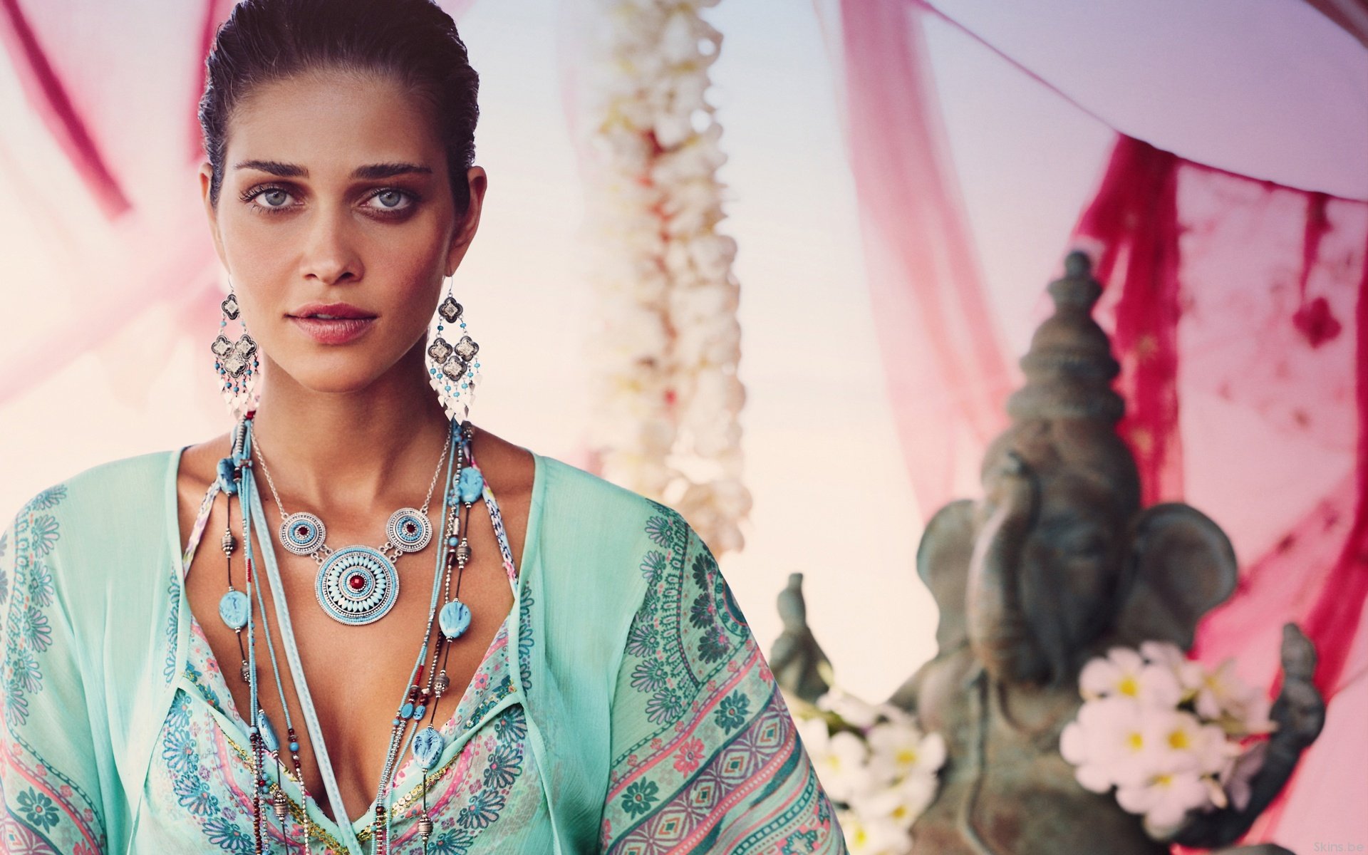 HD desktop wallpaper featuring Ana Beatriz Barros wearing a turquoise patterned outfit with layered jewelry, set against a soft, decorative background.
