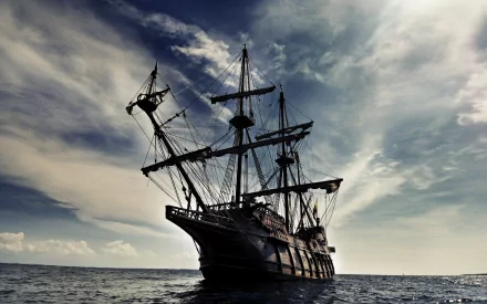 The Black Pearl from Pirates of the Caribbean sails through a dramatic sky, showcasing its iconic pirate ship design in this stunning HD desktop wallpaper.