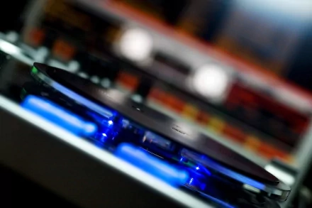 A close-up of a DJ turntable illuminated with blue light, capturing the essence of music and nightlife. This image serves as an energetic HD desktop wallpaper and background.