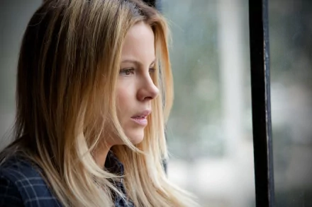 A HD desktop wallpaper featuring a contemplative Kate Beckinsale gazing out a window, showcasing her expressive profile and natural beauty.