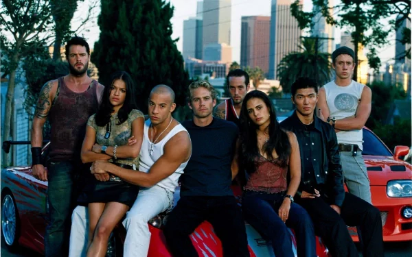 HD desktop wallpaper featuring characters from The Fast and the Furious including Vince, Jesse, Johnny Tran, Mia Toretto, Letty Ortiz, Dominic Toretto, and Brian O'Conner in front of a city backdrop.