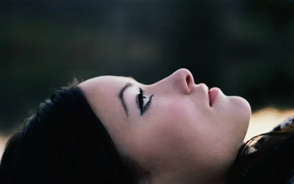 HD PC desktop wallpaper featuring a serene close-up profile of celebrity Olivia Wilde against a blurred natural background.