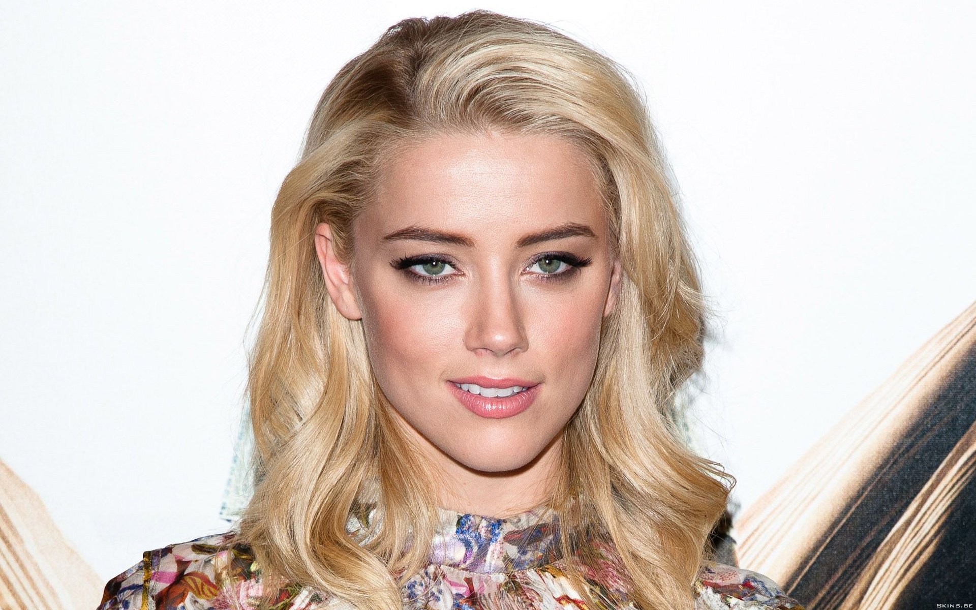 HD desktop wallpaper featuring a close-up of Amber Heard, showcasing her stylish look with flowing blonde hair and striking makeup.