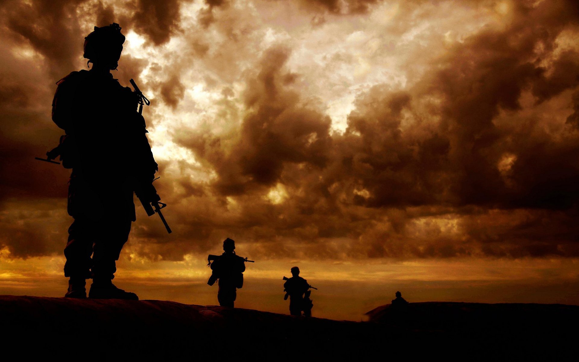 Silhouettes of soldiers against a dramatic sunset sky, capturing the essence of military service. This HD wallpaper serves as an evocative backdrop for a desktop.