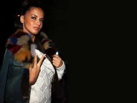 HD PC desktop wallpaper of celebrity Adriana Lima wearing a stylish fur-collared jacket against a black background.