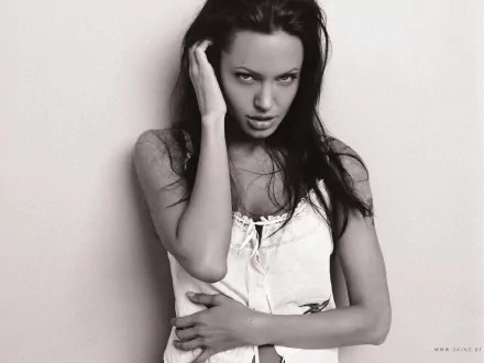 Black and white HD wallpaper featuring Angelina Jolie, capturing her striking expression and elegant pose against a minimalistic background.