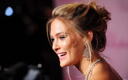 HD PC desktop wallpaper featuring a close-up of celebrity Bar Refaeli smiling, with elegant earrings and soft lighting enhancing the background.