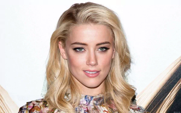 HD desktop wallpaper featuring a close-up of Amber Heard, showcasing her stylish look with flowing blonde hair and striking makeup.
