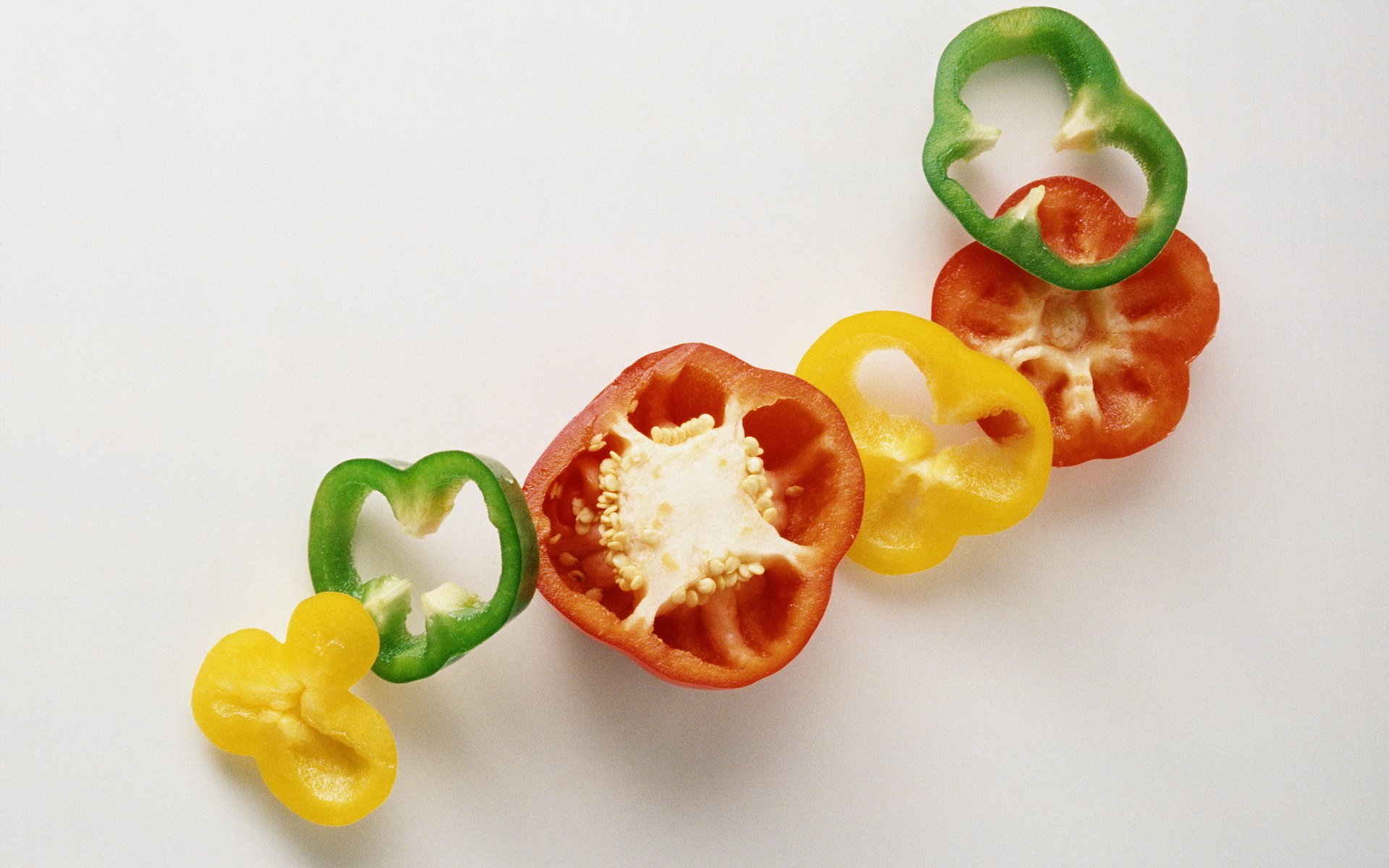 Close-up of colorful pepper slices arranged in a row on a white background, designed as an HD PC desktop wallpaper featuring food and pepper elements.