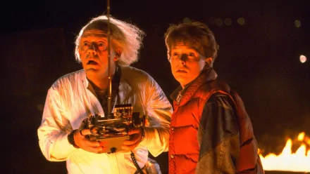 A scene from the movie Back To The Future, featuring Doc Brown and Marty McFly, captures their intense expressions against a dramatic night backdrop. High-definition desktop wallpaper.