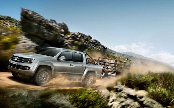 A Volkswagen pickup truck driving fast through a rugged mountainous landscape, kicking up dust, shown in 4K Ultra HD desktop wallpaper quality.