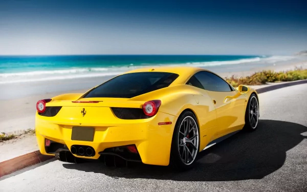 A sleek yellow Ferrari 458 Italia parked by the beach, showcasing its stunning design against the backdrop of turquoise waters and a clear sky.
