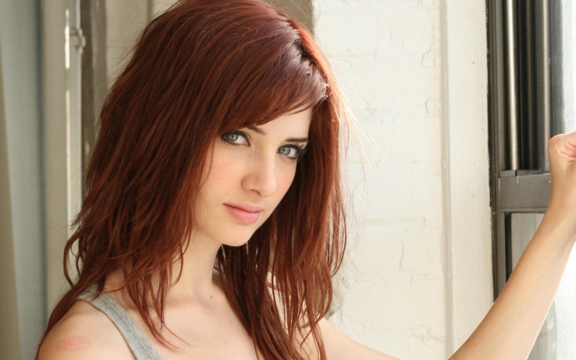HD desktop wallpaper featuring celebrity Susan Coffey, showcasing her striking features and vibrant hair, set against a softly lit interior backdrop.