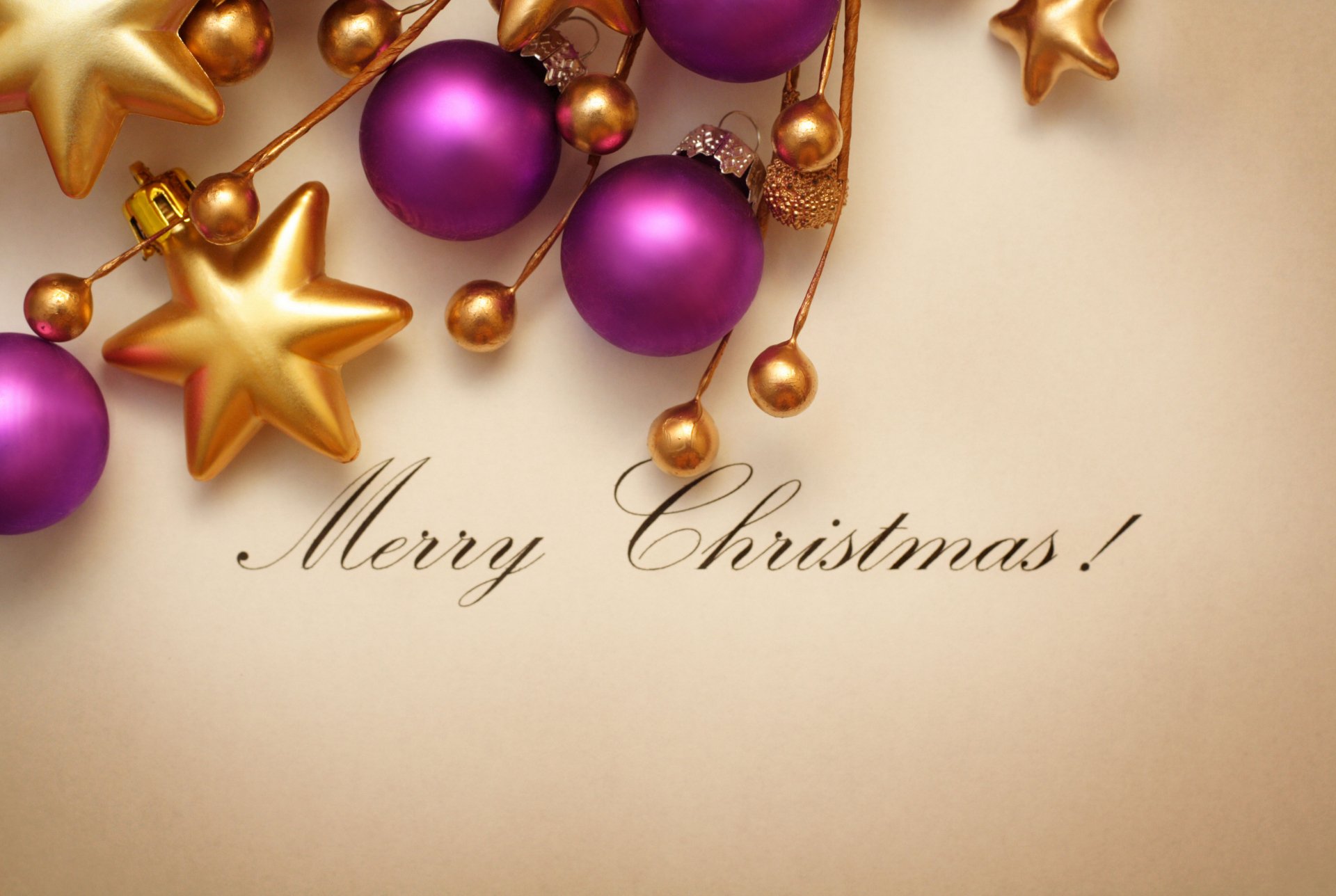 A festive holiday image featuring vibrant purple and gold Christmas ornaments and stars, with the elegant text Merry Christmas! set against a warm backdrop.