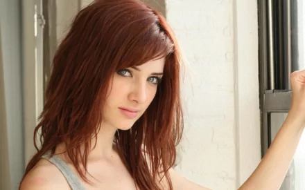 HD desktop wallpaper featuring celebrity Susan Coffey, showcasing her striking features and vibrant hair, set against a softly lit interior backdrop.