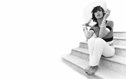 Black-and-white HD desktop wallpaper of celebrity Milla Jovovich sitting barefoot on outdoor steps, exuding a relaxed and stylish vibe.