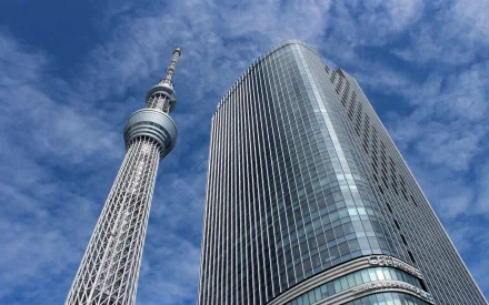 HD desktop wallpaper featuring the Tokyo Skytree and a modern skyscraper set against a clear blue sky in Tokyo, Japan.