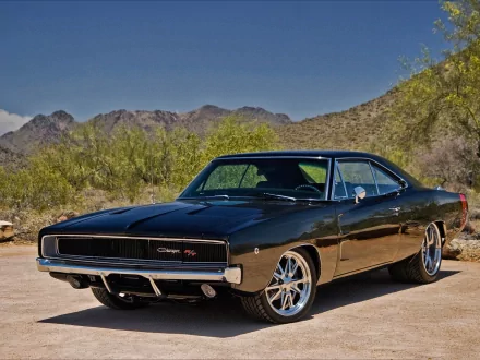 A sleek black Dodge Charger parked against a backdrop of mountains, showcasing its classic design and modern wheels, making for an impressive HD desktop wallpaper.