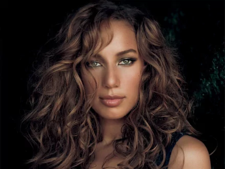 HD desktop wallpaper featuring a close-up portrait of Leona Lewis with wavy hair and green eyes, highlighting music and artistic expression.