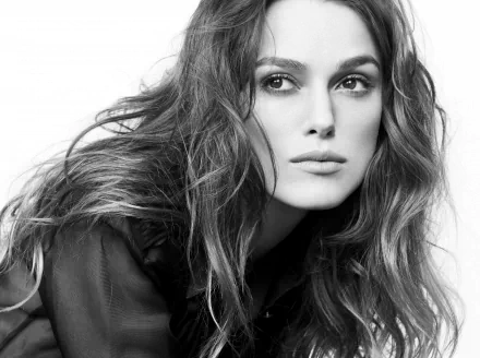 HD desktop wallpaper featuring a striking black and white portrait of Keira Knightley, showcasing her expressive features and flowing hair.